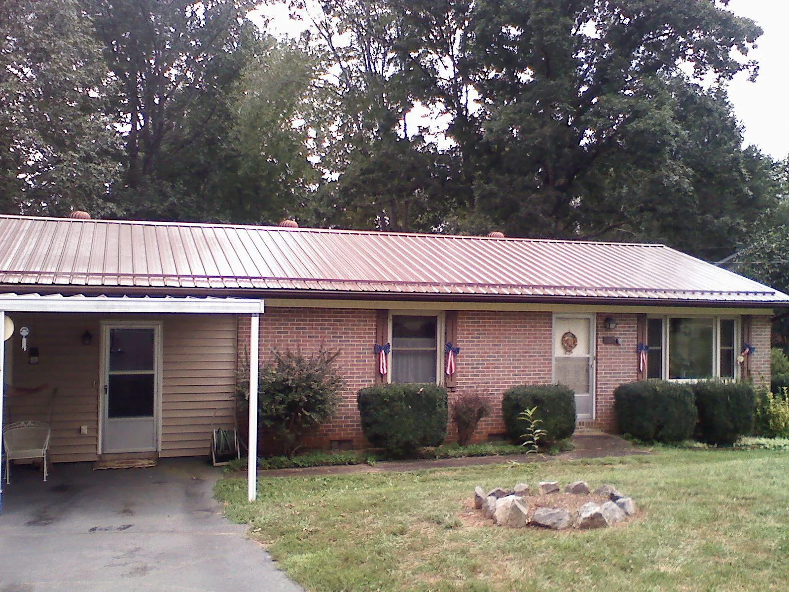 Bronze metal roof and carport on a brick ranch home — Roof Repair work by our crew in Woody Creek